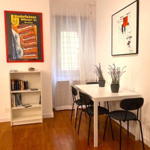una sala da pranzo con tavolo e sedie bianchi di Lazy Time Apartment a Roma