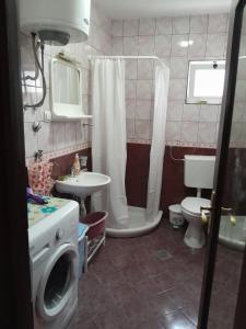 a bathroom with a toilet sink and a washing machine at Apartment Potpara in Tivat