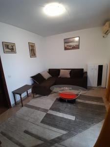 uma sala de estar com um sofá e uma mesa em Apartment Potpara em Tivat