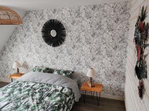 ル・ギルヴィネックにあるLa maison rougeのベッドルーム1室(ベッド1台付)が備わります。壁に壁画が飾られています。