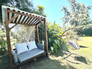 een schommel op de veranda met een blauwe stoel in een tuin bij Temporario yerba buena country in Yerba Buena