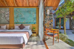 um quarto com uma cama, uma mesa e uma cadeira em Tam Coc Serenity Hotel & Bungalow em Ninh Binh