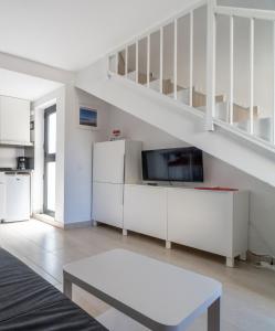 a living room with white furniture and a staircase at Casa Hugo in Costa Calma