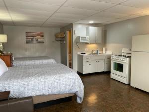 1 dormitorio pequeño con 1 cama y cocina en Sunset Beach Resort, en Osage Beach