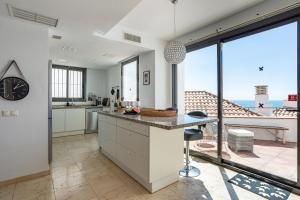 a kitchen with white cabinets and a large window at Modern townhouse with stunning view in Fuengirola