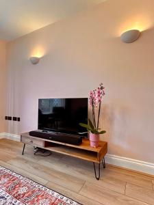 a living room with a large flat screen tv at Nature Inspired Bungalow with 3 rooms - 10 mins from Manchester Airport in Timperley