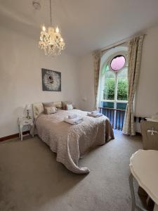 a bedroom with a large bed and a chandelier at The Chapel Guest House in St Austell