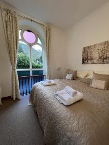a bedroom with two towels on a bed with a window at The Chapel Guest House in St Austell