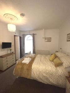 a bedroom with a large bed and a window at The Chapel Guest House in St Austell