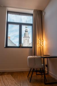 una ventana en una habitación con una mesa y un edificio en Hôtel Le Manoir, en Marche-en-Famenne