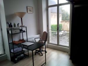 uma mesa e uma cadeira num quarto com uma janela em bel appart. / résidence de standing / plein centre em Château-Thierry