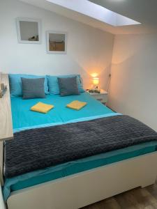 una camera da letto con un grande letto con lenzuola blu di Apartman Una a Batajnica