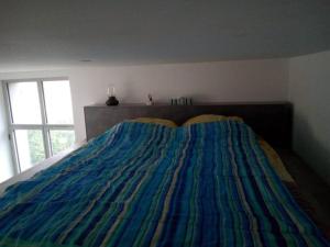 um quarto com uma cama com um cobertor colorido em bel appart. / résidence de standing / plein centre em Château-Thierry