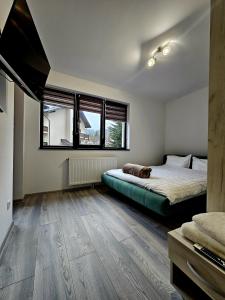 un dormitorio con una cama y un gato sobre ella en Snow Apartament en Buşteni