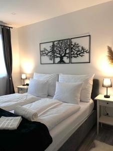 a bedroom with a large bed with three pictures on the wall at Secret Lakeside in Frauenkirchen
