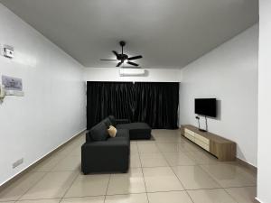 a living room with a couch and a television at SDC Suite Home II in Lahad Datu
