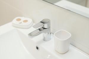 lavabo con grifo y taza en Casa Cauma Apartamento en Albarracín