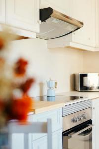 a kitchen with white cabinets and a stove top oven at Casa Cauma Apartamento in Albarracín