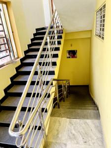 a staircase in a building with blue stairs and yellow walls at sai bliss in Puttaparthi