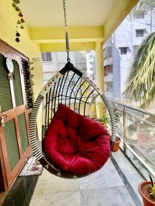 a red chair hanging on a balcony at sai bliss in Puttaparthi