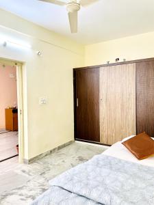 een slaapkamer met een groot bed en een houten kast bij sai bliss in Puttaparthi