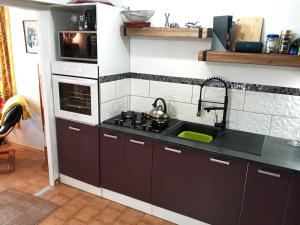 a kitchen with a sink and a microwave at Volets Verts in Montauriol