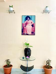een foto van een vrouw aan een muur met een tafel bij sai bliss in Puttaparthi