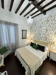 カディスにあるPalacete de La Alameda - Adults Only-の白い大型ベッドと壁が備わるベッドルーム1室が備わります。
