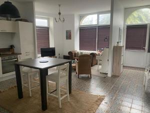 een keuken en woonkamer met een tafel en stoelen bij TY MAI - petite maison proche plages et commerces in Trébeurden