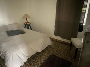 een slaapkamer met een wit bed en een raam bij TY MAI - petite maison proche plages et commerces in Trébeurden