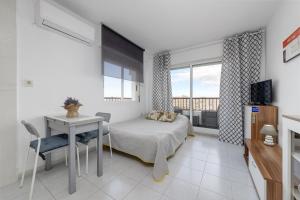 - une chambre avec un lit, une table et une fenêtre dans l'établissement Estudio Jardín del Mar, à Torrevieja