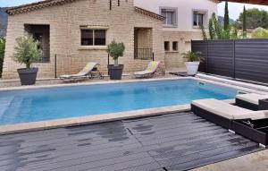 a swimming pool with chairs and a house at La Maison De Celine in Beaumes-de-Venise