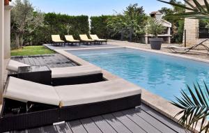 a swimming pool with lounge chairs in a backyard at La Maison De Celine in Beaumes-de-Venise