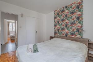 een slaapkamer met een groot bed met een bloemenmuur bij L’oasis in Seyssinet-Pariset