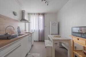 een witte keuken met een wastafel en een koelkast bij L’oasis in Seyssinet-Pariset