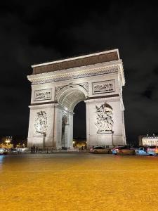 a large monument is lit up at night at Charming apartment near La Défense, Paris in Bezons