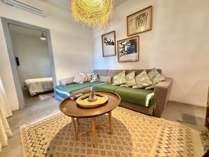 uma sala de estar com um sofá e uma mesa em Tolila Sidi Bou Said, grande terrasse avec vue em Sidi Bou Said
