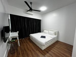 a bedroom with a white bed and a ceiling fan at SDC Suite Home II in Lahad Datu