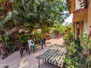 a patio with chairs and tables and a tree at Jaat House in Bhuj