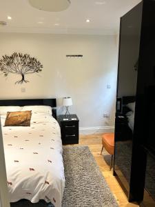 a bedroom with a bed with a tree on the wall at Foxes Den at Foxesway in Kirkby on Bain