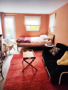 - un salon avec un lit et un canapé dans l'établissement Peaceful green setting near to Paris Center, à Pantin