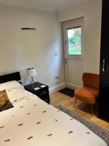 a bedroom with a bed and a chair and a window at Foxes Den at Foxesway in Kirkby on Bain