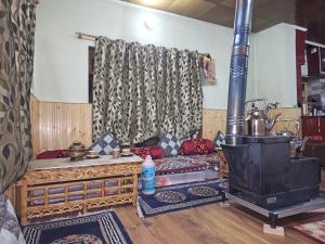 a living room with a wood stove in a room at PASANG HOMESTAY in Leh