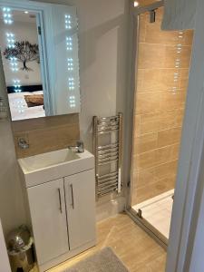 a bathroom with a white sink and a shower at Foxes Den at Foxesway in Kirkby on Bain