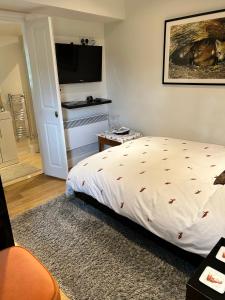 a bedroom with a bed and a flat screen tv at Foxes Den at Foxesway in Kirkby on Bain