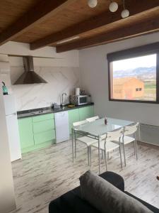 a kitchen and dining room with a table and chairs at Apartamentos la Vega de Granada in Ambroz