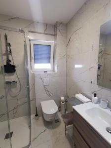a bathroom with a shower and a toilet and a sink at Gita Suite in Orebić +14 photos