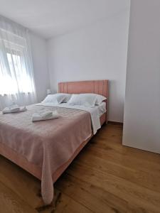 a bedroom with a large bed with a wooden floor at Gita Suite in Orebić