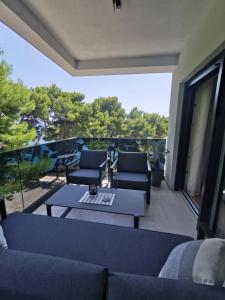 a living room with a couch and a table on a balcony at Gita Suite in Orebić