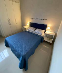 a bedroom with a blue bed with a sign that reads my last supper at Apartamento aconchegante e bem localizado! in Vitória